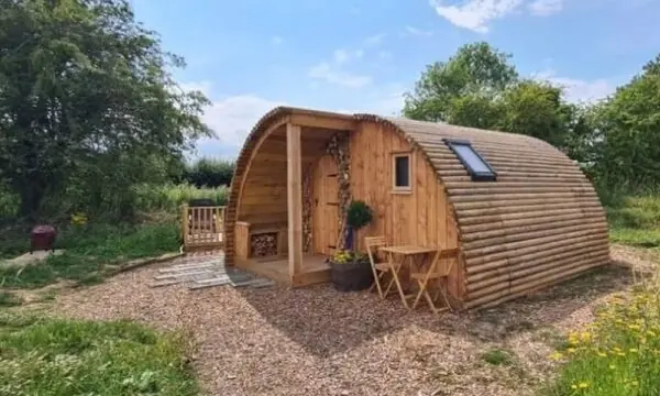 Pheasant Wooden holiday glamping lodge in summer next to the canal image
