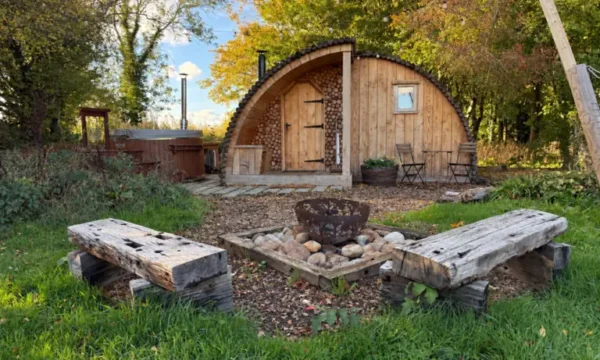 Fox Lodge with a covered entrance and fire pit in the surrounding woodland