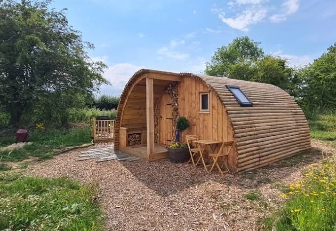 Wooden glamping lodge surrounded by trees at Heygates Lodging in Northamptonshire